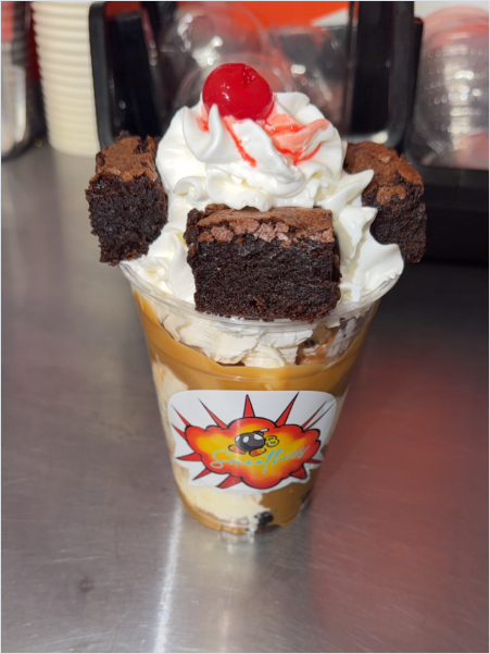 Brownie sundae cup topped with whipped cream, brownies, and a cherry