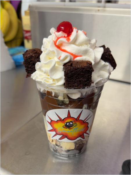 Loaded brownie sundae with whipped cream and cherry in branded cup